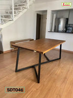 Modern wooden dining table with black metal legs in a bright home interior