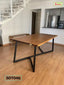 Modern wooden dining table with black metal legs in a bright home interior