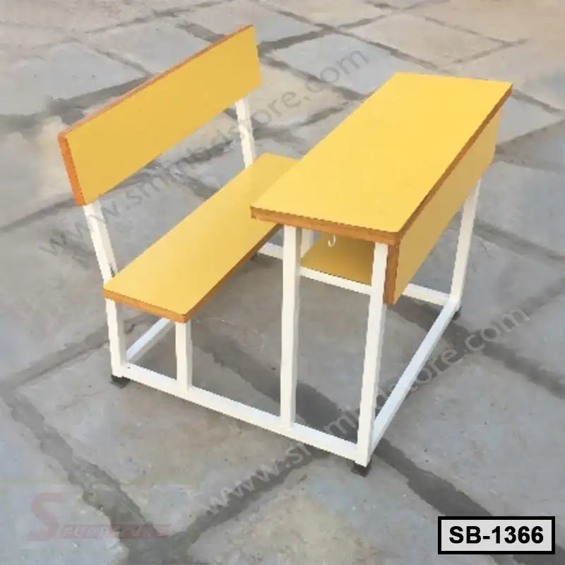 Yellow school bench and desk set with white metal frame on concrete floor