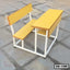 Yellow school bench and desk set with white metal frame on concrete floor