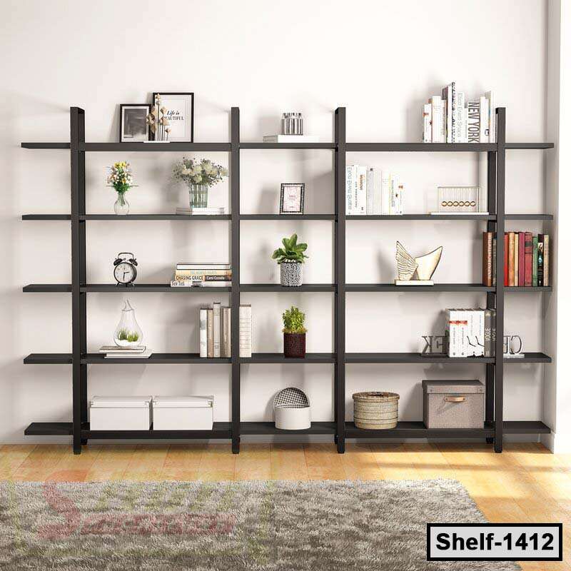 Modern black wooden bookshelf with books, plants, and decorative items in a living room.