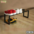 Modern black metal shoe rack on wooden floor with three pairs of shoes, space-saving design