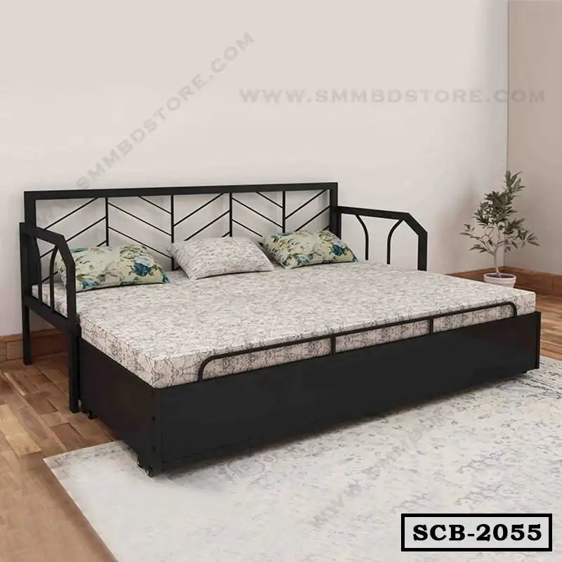 Modern metal sofa cum bed with floral cushions in a minimal living room