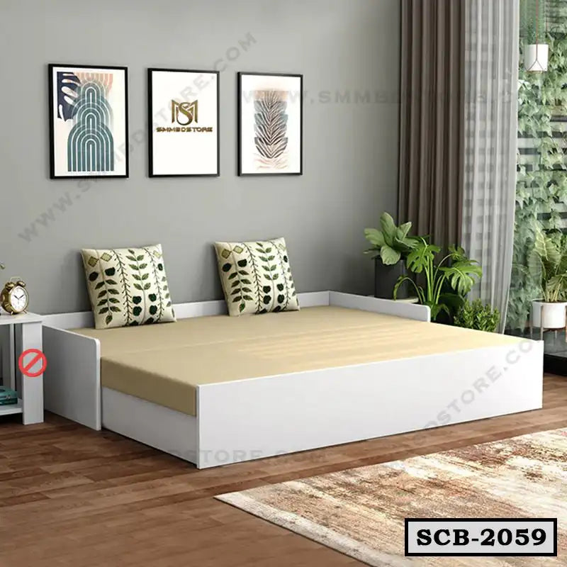 Modern white sofa cum bed with beige mattress and leaf print cushions in a bright living room Main image