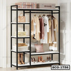 Standing closet organizer with shelves, hanging clothes, pillows, boxes, shoes, and bags