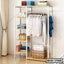 Standing closet organizer with hanging clothes, open shelves, and storage baskets in a modern room