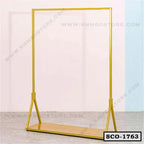 Yellow metal standing closet organizer with open hanging rod and lower storage shelf