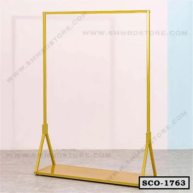 Yellow metal standing closet organizer with open hanging rod and lower storage shelf
