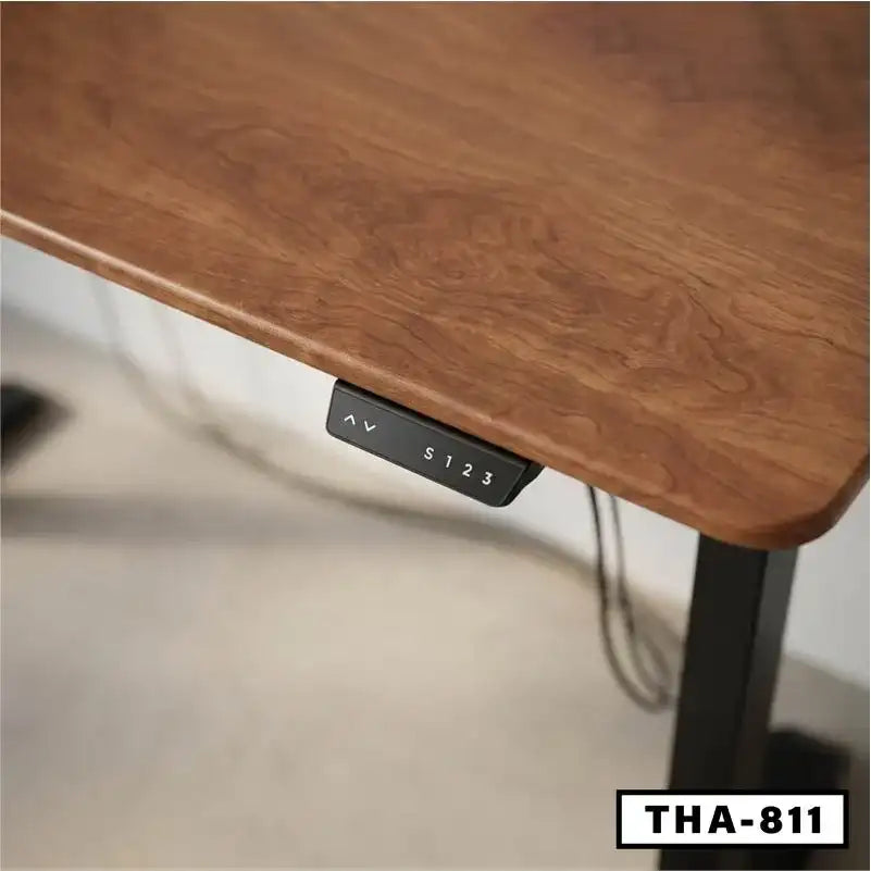 Close-up of wooden height adjustable standing desk with control panel, black metal legs