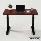 Height adjustable standing computer desk with dark wood top, laptop, mug, plant, and notebook
