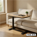 Modern standing desk with wooden top and black base beside a beige sofa in a bright room