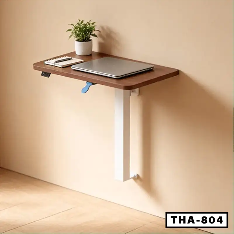 Wall-mounted standing laptop table with wooden top, metal leg, and workspace items