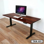 Modern standing desk with wood top, black metal legs, and computer setup in home office