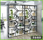 Modern steel bookshelf with geometric design, holding books and plants in office setting