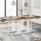 Modern steel dining table with wood top and white metal legs in a bright dining room