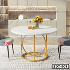 Modern round steel dining table with white top and gold base, set in a stylish dining room