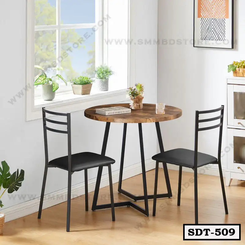 Modern steel dining table with two black chairs in a bright, minimalist dining room