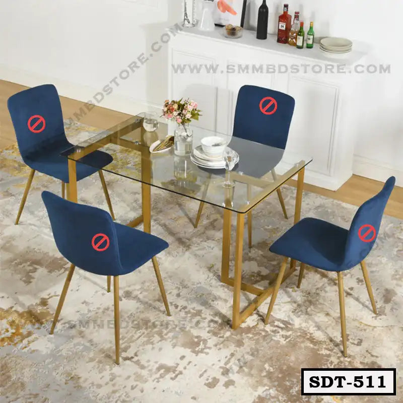 Modern glass dining table with gold metal legs and four blue chairs in a contemporary dining room.
