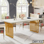 Modern steel dining table with gold legs and cream top in a stylish dining room