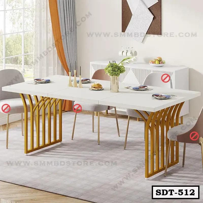Modern steel dining table with white top, gold legs, surrounded by grey chairs in a bright dining room.