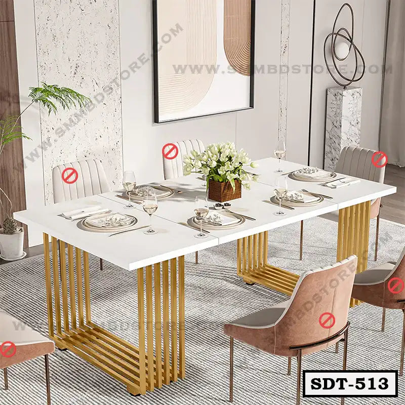 Modern steel dining table with white tabletop, gold legs, six upholstered chairs, and elegant table setting in a contemporary dining room. Main image