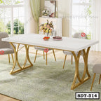 Modern steel dining table with white top and gold legs in a bright living room setting