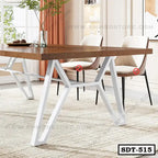 Modern steel dining table with wooden top and white metal legs in a bright dining room