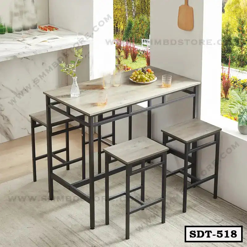 Modern steel dining table set with four matching stools in a bright kitchen setting Main image