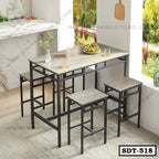 Modern steel dining table set with four matching stools in a bright kitchen setting