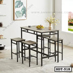 Modern steel dining table with matching stools in a bright dining room setting