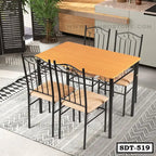 Modern steel dining table with four chairs, wood top, black metal frame, set on patterned rug