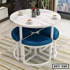 Round white marble dining table with blue cushioned stools in a modern living room