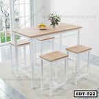 Modern steel dining table with four matching stools in a bright room, wood top finish