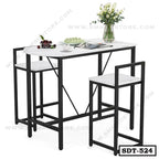 Modern steel dining table set with two chairs, black frame, white tabletop, and floral decor.