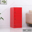 Red steel file cabinet with three lockable drawers, modern office furniture beside sofa
