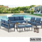 Modern steel outdoor sofa set with blue cushions by a swimming pool on a patio.