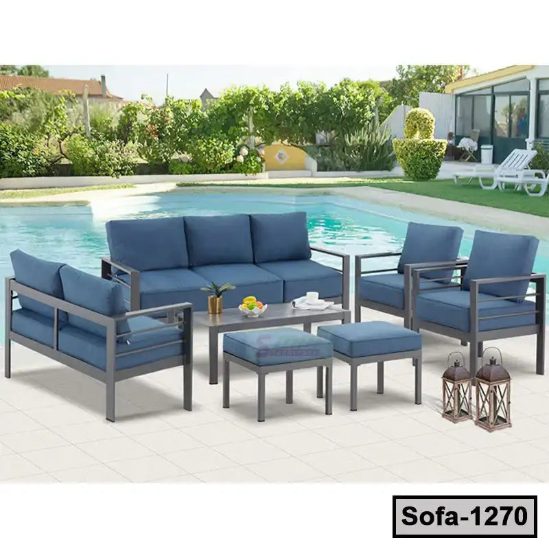 Modern steel outdoor sofa set with blue cushions by a swimming pool on a patio.