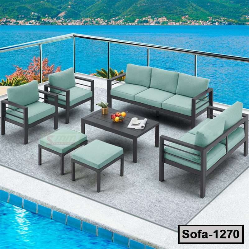 Modern steel outdoor sofa set with light blue cushions on a patio by a pool and waterfront view