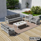Modern outdoor steel sofa set with gray cushions on wooden deck, garden background