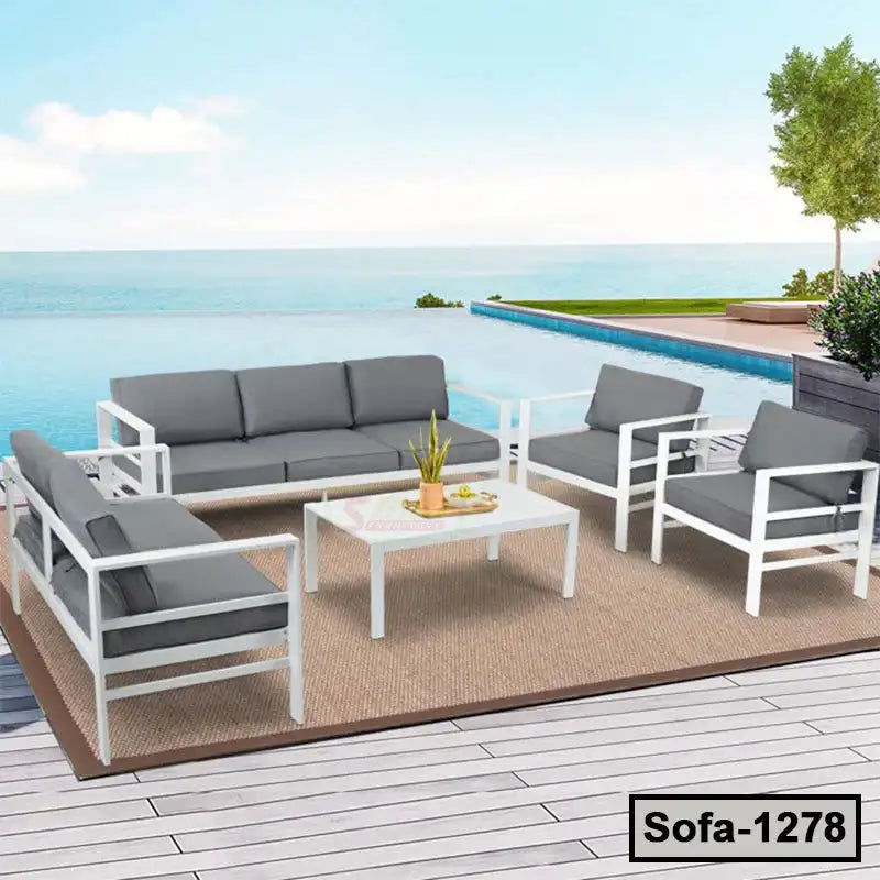 Modern outdoor steel sofa set with gray cushions by a pool and ocean view