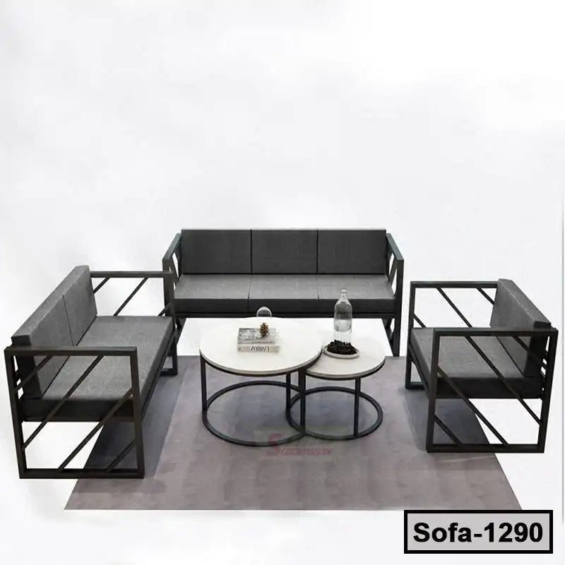 Modern steel-frame sofa set with grey cushions and two round coffee tables on a rug Main image