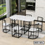 Modern steel dining table set with white marble top and six matching chairs in a bright dining room