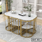 Modern marble-top steel dining table with gold frame and matching stools in a bright room