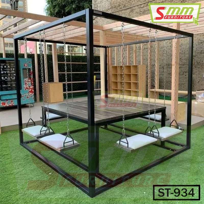 Outdoor swing table set with cushioned swing seats and black metal frame on artificial grass. Main image