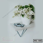 Modern wall shelf with white vase of flowers and model car for home or office decor