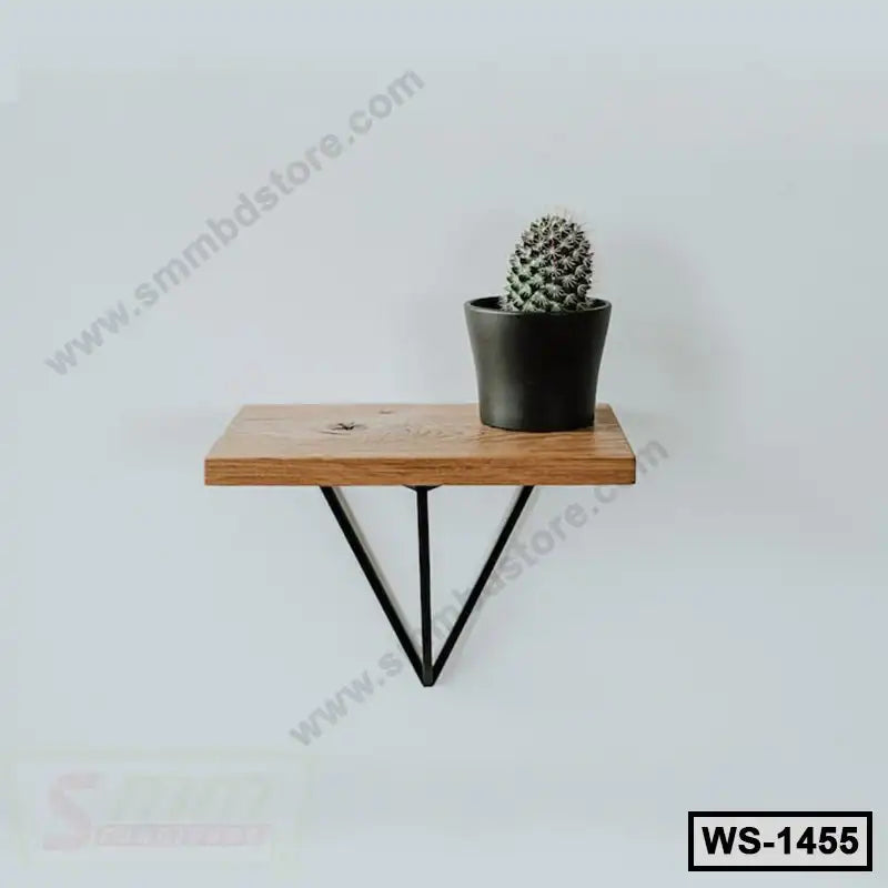 Modern wooden wall shelf with black metal brackets and potted cactus on white wall