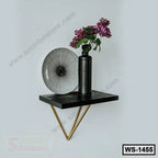 Modern wall shelf with black metal vase and geometric plate, home decor accent.