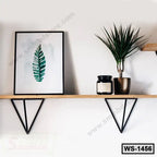 Modern wooden wall shelf with black metal brackets, holding a framed leaf print, potted plant, and candle.