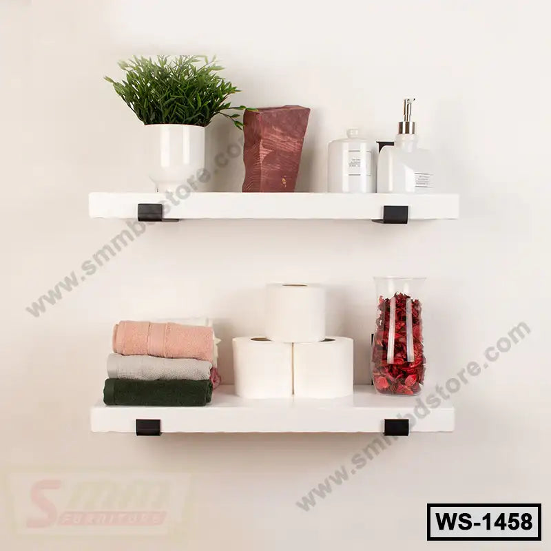 White wall shelves with bathroom essentials, towels, toilet paper, and decor accents