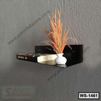 Modern black wall shelf with a book and decorative vase on a gray textured wall